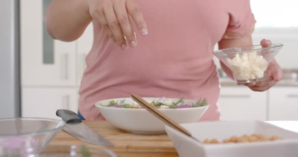 キッチンでチーズと野菜サラダを作るハッピープラスサイズの女性 ゆっくりとした動き レシピ 家庭生活と健康的なライフスタイル 変更されていない — ストック動画
