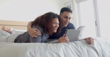 Sabahları tablet kullanarak yatakta uzanan ve kucaklaşan mutlu eşcinsel çift, yavaş çekim. İletişim, boş zaman, gay, ilişki, birliktelik, ev hayatı ve yaşam tarzı, değişmemiş.