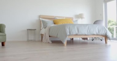 Geniş güneşli yatak odasında çift kişilik yatak, pencereden bahçeye, kopyalama alanı, yavaş çekim. Mülkiyet, ev, iç dekorasyon, yaz, rahatlama, ev hayatı ve yaşam tarzı, değiştirilmemiş.