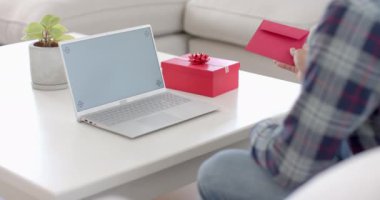 Kartı ve yeteneği olan melez bir adam. Evinde fotokopi makinesiyle laptop görüntülü görüşme yapıyor. Yavaş çekim. İletişim, doğum günü, sevgililer günü, kutlama, romantizm ve yaşam tarzı, değişmemiş.
