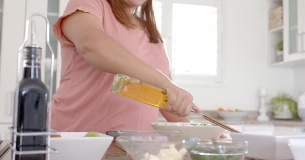 キッチンでオリーブオイルでサラダをドレッシングするハッピープラスサイズの女性 コピースペース スローモーション 食べ物 家庭生活 健康的なライフスタイル 変わらない — ストック動画