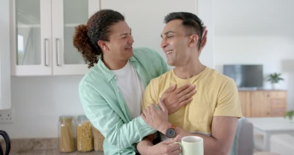 ハッピー多様なゲイ男性カップルはコーヒーを飲んで 晴れたキッチンで抱擁し ゆっくりとした動き フリータイム トータルネス 家庭生活 ライフスタイル — ストック動画
