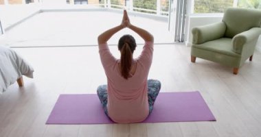 Artı, yerde oturup yoga meditasyonu, fotokopi alanı, ağır çekimde çalışan melez bir kadın. Lotus pozisyonu, yoga, meditasyon, refah, ev hayatı ve sağlıklı yaşam tarzı, değişmemiş.