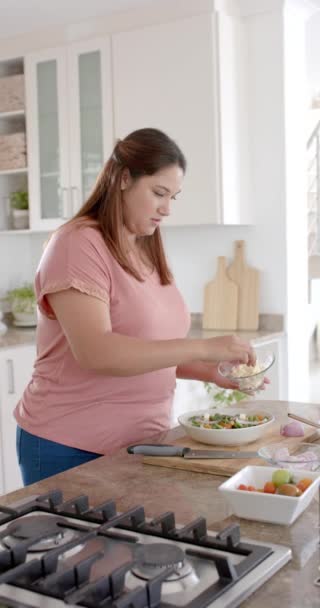 キッチンで健康的なサラダを準備するプラスサイズの女性の垂直ビデオ スローモーション 食べ物 家庭生活 健康的なライフスタイル 変わらない — ストック動画