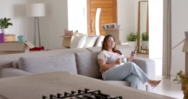 Size Biracial Woman Sofa Using Smartphone Having Coffee New Home — Stock Video