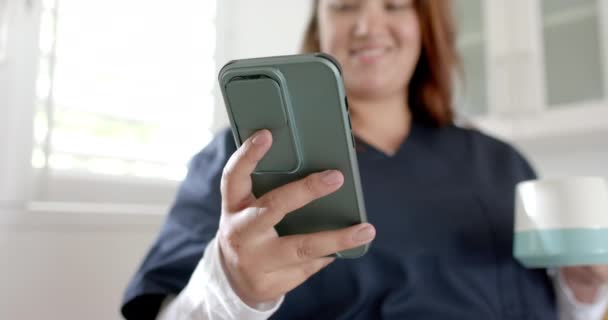 Mutlu Melez Kadın Doktor Kahve Içiyor Evde Akıllı Telefon Kullanıyor — Stok video