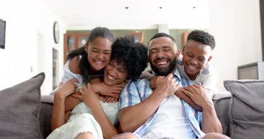Afrikalı mutlu bir Amerikalı kızın ve oğlunun portresi. Ebeveynleri kanepeye sarılıyor, ağır çekimde. Çocukluk, ebeveynlik, aile, birliktelik, aşk, ev hayatı ve yaşam tarzı, değişmemiş..