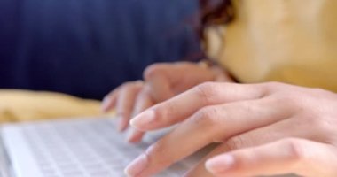 Dizüstü bilgisayar, gülümseme, kopyalama alanı ve ağır çekim kullanarak kanepede oturan iki ırklı genç kız. İletişim, teknoloji, çalışmalar, ergenlik, ev hayatı ve yaşam tarzı, değişmemiş.