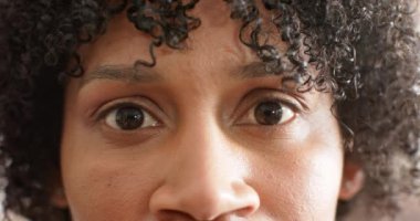 Kahverengi gözlü, mutlu Afro-Amerikan kadının portresi güneşte gülümsüyor, ağır çekimde. Yaz, boş zaman, rahatlama, ev hayatı ve yaşam tarzı, değişmemiş..