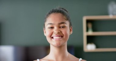 Afro-Amerikalı mutlu bir kızın portresi oturma odasında gülümsüyor ve gülüyor, ağır çekimde. Çocukluk, ev hayatı ve yaşam tarzı değişmedi..