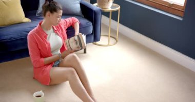 Evde oturmuş kitap okuyan, mekanı kopyalayan, ağır çekimde odaklanmış iki ırklı genç kız. Rahatlama, hobiler, ergenlik, boş zaman, ev hayatı ve yaşam tarzı, değişmemiş.