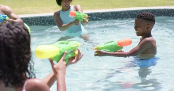 Felices Padres Afroamericanos Hijo Hija Jugando Con Pistolas Agua Piscina — Vídeos de Stock