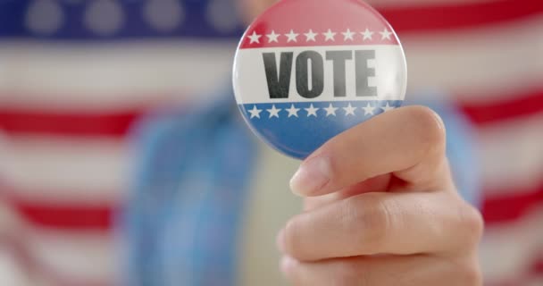 Hand Biracial Teenage Girl Agaisnt American Flag Holding Vote Badge — Stock Video