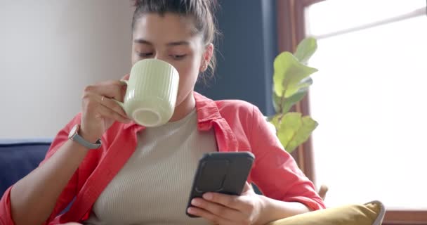 Focado Biracial Adolescente Bebendo Chá Usando Smartphone Casa Espaço Cópia — Vídeo de Stock