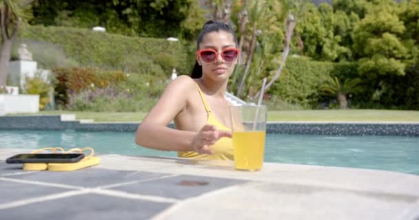 Menina Adolescente Birracial Feliz Óculos Sol Piscina Ensolarada Com Bebida — Vídeo de Stock