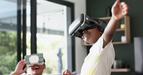 ハッピーアフリカ系アメリカ人の兄弟姉妹は ソファーで遊ぶヘッドセット ゆっくりとした動き 子供時代 コミュニケーション デジタルインターフェース テクノロジー 家庭生活 ライフスタイル — ストック動画