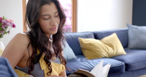 Felice Ragazza Adolescente Biraciale Seduta Sul Divano Leggere Libro Sorridente — Video Stock