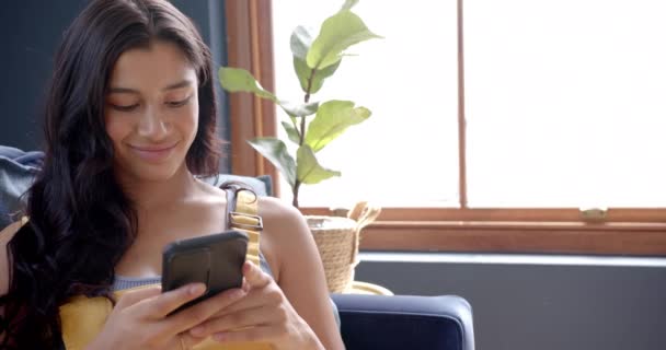 Feliz Chica Adolescente Birracial Relajarse Sofá Con Teléfono Inteligente Sonriendo — Vídeo de stock