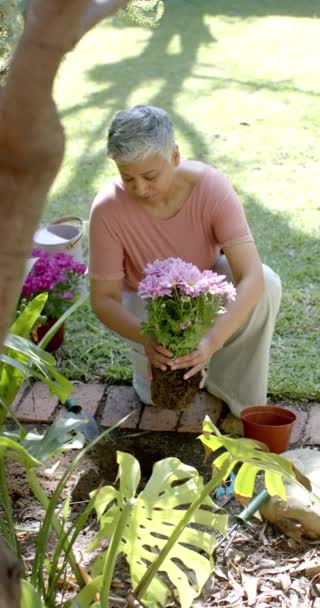 Vídeo Vertical Feliz Mujer Birracial Senior Que Trabaja Jardín Cámara — Vídeo de stock