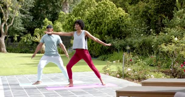アフリカ系アメリカ人のカップルは 庭に立ってヨガを練習し スペースをコピーし ゆっくりとした動きをします 一緒に フィットネス 健康と健康的なライフスタイル 変わらない — ストック動画