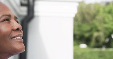 Bahçede gülümseyen, fotokopi çeken ve ağır çekimde gülümseyen yaşlı Afrikalı Amerikalı kadının yarım portresi. Refah ve sağlıklı yaşlı yaşam tarzı, değişmedi..