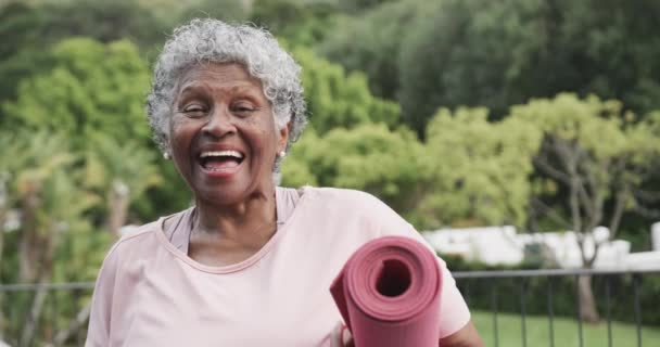 Retrato Una Mujer Afroamericana Mayor Feliz Sosteniendo Esterilla Yoga Riéndose — Vídeo de stock