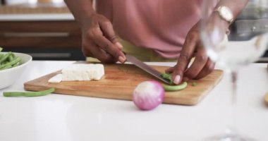 Kıdemli Afro-Amerikan kadınlarının orta bölümü. Yemek pişirme, sebze hazırlama, fotokopi alanı, ağır çekim. Yemek, yemek, refah ve sağlıklı yaşlı yaşam tarzı, değişmemiş..