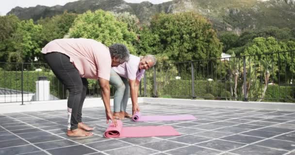 Senior African American Amiche Che Spiegano Stuoie Yoga Sul Balcone — Video Stock