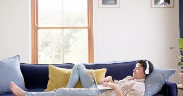 집에서 노트북 슬로우 모션을 소파에 헤드폰을 커뮤니케이션 생활양식 변하지 — 비디오