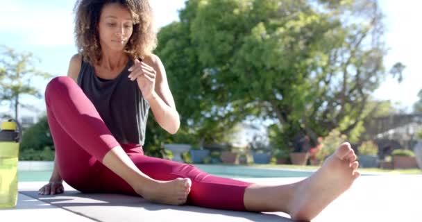 Szczęśliwa Birasowa Kobieta Ćwicząca Jogę Siedząc Przy Basenie Słonecznym Ogrodzie — Wideo stockowe