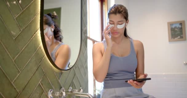 Biracial Gadis Remaja Mengenakan Masker Mata Menggunakan Smartphone Kamar Mandi — Stok Video