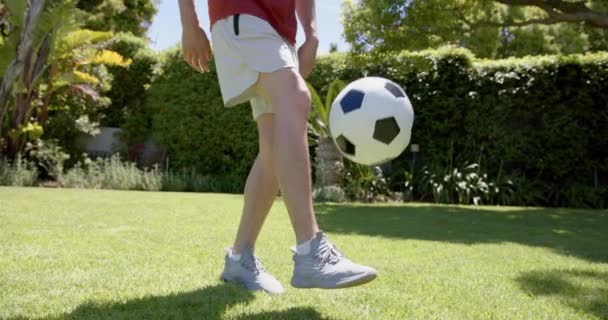 Niski Odcinek Dwurasowego Mężczyzny Żonglującego Piłką Nożną Stopami Słonecznym Ogrodzie — Wideo stockowe