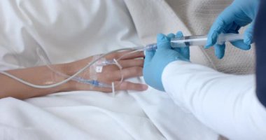 Eldivenli erkek doktor, çift ırklı kadın hastaya şırınga enjekte ediyor, yavaş çekimde. Tıbbi malzeme, tedavi, bakım, hastane, iş, ilaç ve sağlık hizmetleri, değiştirilmemiş.