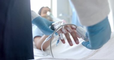 Erkek doktor, çift ırklı kadın hastanın parmağına oksimetre takıyor. Kopya alanı, ağır çekim. Tıbbi malzeme, tedavi, bakım, hastane, iş, ilaç ve sağlık hizmetleri,