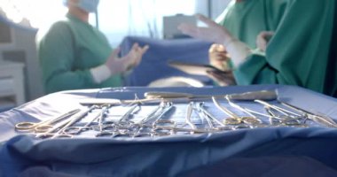 Operasyon sırasında maskeli çeşitli kadın ve erkek cerrahlar ağır çekimde tartışıyorlar. Takım çalışması, ameliyathane, cerrahi, hijyen, tıbbi ekipman, hastane, tıp ve sağlık hizmetleri, değiştirilmemiş.