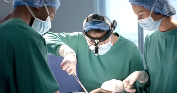 不同的女医生和男医生在手术中使用手术工具和前灯 动作缓慢 协同工作 医疗设备 医药和医疗保健 未经改动 — 图库视频影像