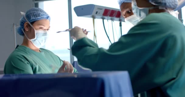 Cirurgiões Femininos Masculinos Diversos Máscaras Passando Ferramentas Cirúrgicas Durante Operação — Vídeo de Stock