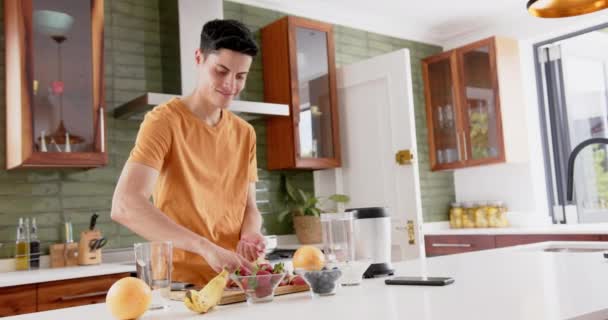 Homem Biracial Feliz Preparando Smoothie Frutas Saudável Com Liquidificador Cozinha — Vídeo de Stock