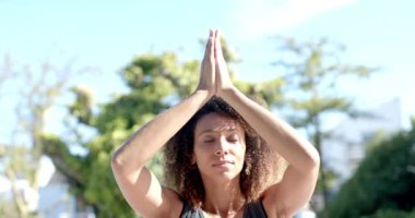 Mutlu melez kadın yoga meditasyonu yapıyor güneşli bahçede oturuyor, ağır çekimde. Meditasyon, yoga, yaz, refah ve sağlıklı yaşam tarzı, değişmemiş.