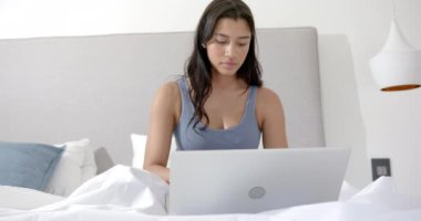 Sabahları yatakta dizüstü bilgisayar, kopyalama alanı ve ağır çekim kullanarak odaklanmış iki ırklı genç kız. İletişim, teknoloji, ergenlik, ev hayatı ve yaşam tarzı, değişmemiş..