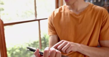 Oturma odasında tablet tablet kullanan düşünceli bir çift ırklı adam. Kopya alanı, ağır çekim. İletişim, boş zaman, ev hayatı ve yaşam tarzı, değiştirilmemiş.