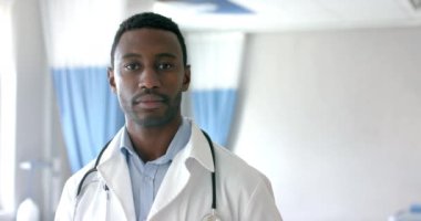 Afro-Amerikan erkek doktor portresi hastane koğuşunda gülümsüyor, kopyalama alanı, ağır çekim. Hastane, iş, ilaç ve sağlık hizmetleri, değiştirilmemiş.