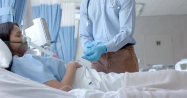 Eldivenli erkek doktor, çift ırklı kadın hastaya şırınga enjekte ediyor, yavaş çekimde. Tıbbi malzeme, tedavi, bakım, hastane, iş, ilaç ve sağlık hizmetleri, değiştirilmemiş.