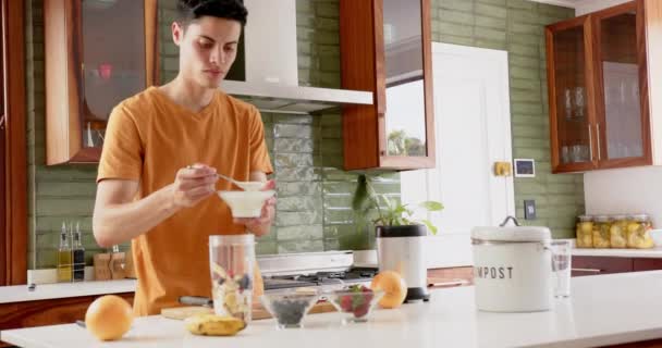 Biracial Man Förbereder Frukt Smoothie Lägga Yoghurt Till Mixer Köket — Stockvideo