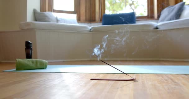 熏香粘在地板上的烟道在瑜伽垫上在家里 活动和住房 — 图库视频影像