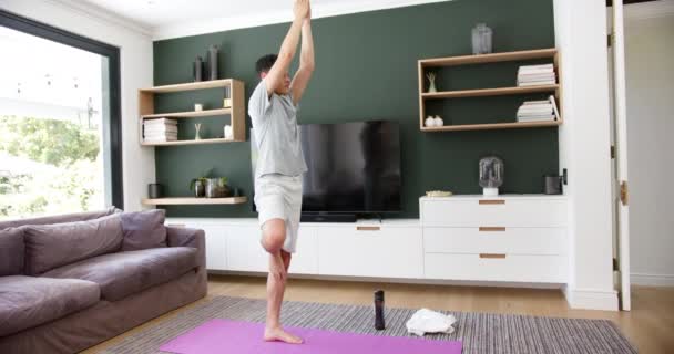 Yoga Yapan Çift Irklı Bir Adam Oturma Odasında Tek Ayak — Stok video