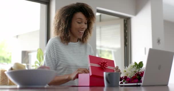 Счастливая Расовая Женщина Подарком Цветами Видео Звонком Ноутбуке Дома Замедленная — стоковое видео