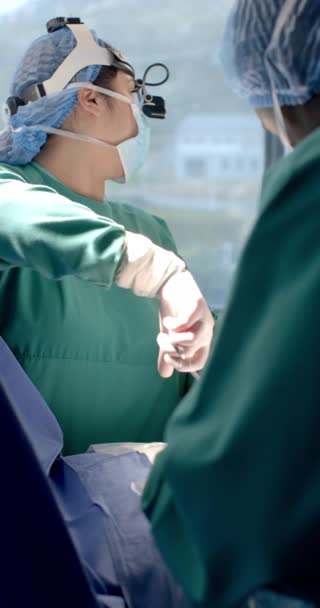 术中佩戴前灯 慢动作的高加索女外科医生的垂直视频 手术室 医疗设备 医院和医疗服务 未经改动 — 图库视频影像