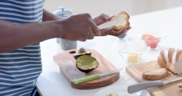Joven Hombre Afroamericano Preparando Desayuno Una Cocina Luminosa Está Esparciendo — Vídeo de stock