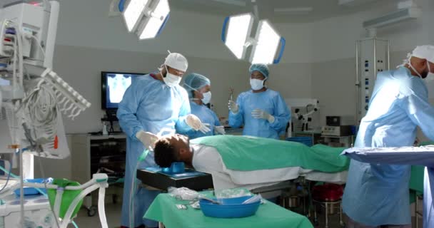 多样化的外科医生团队在医院里工作 有复制空间 他们专注于在一个设备齐全的手术室里进行外科手术 动作缓慢 — 图库视频影像